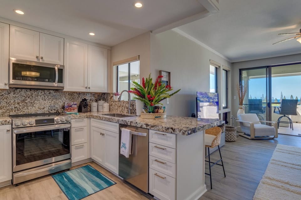 Start your mornings barefoot on cool tile, brewing coffee in this coastal kitchen while sunlight filters through the palms outside    