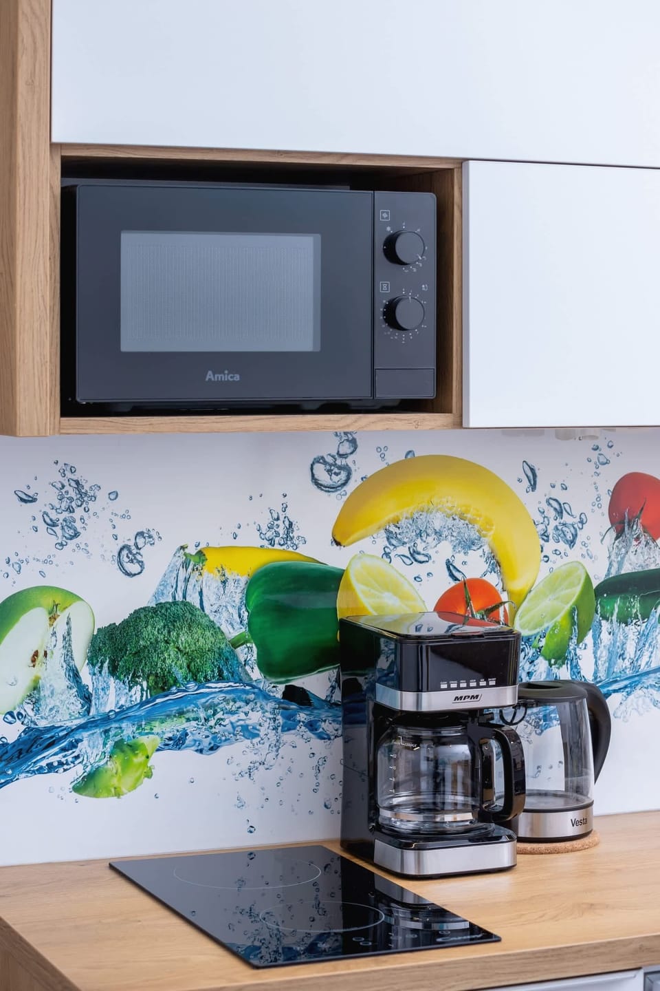 A close-up of the kitchen with a coffee maker and colorful backsplash, creating a lively and inviting atmosphere.
