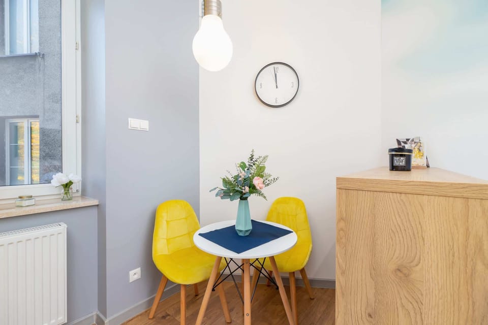 A dining area with a round table, yellow chairs, and a wooden cabinet, creating a cozy and functional space.
