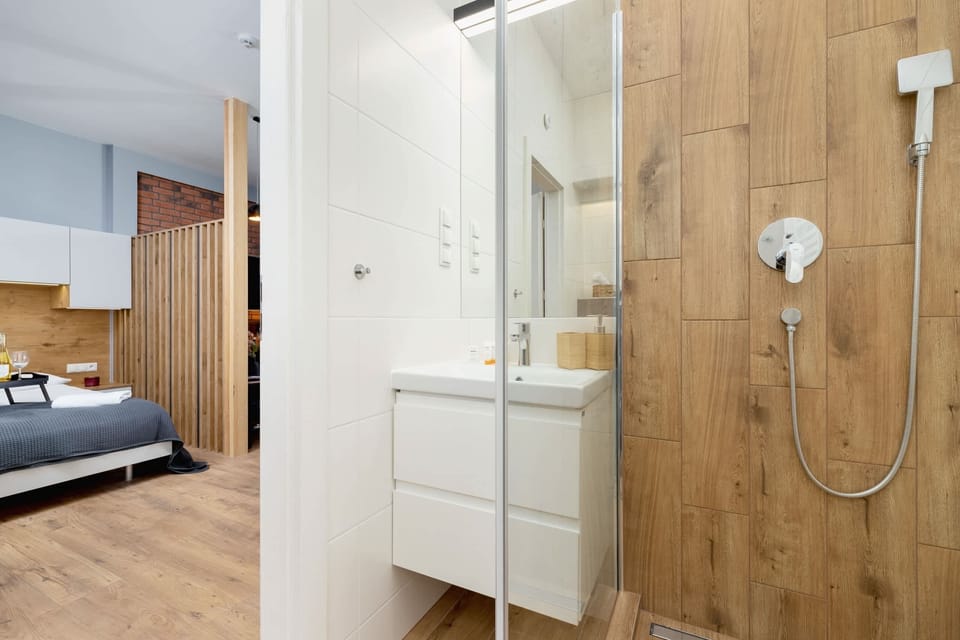 A modern bathroom with wood-style tiles, a walk-in shower, and a clean, elegant design.
