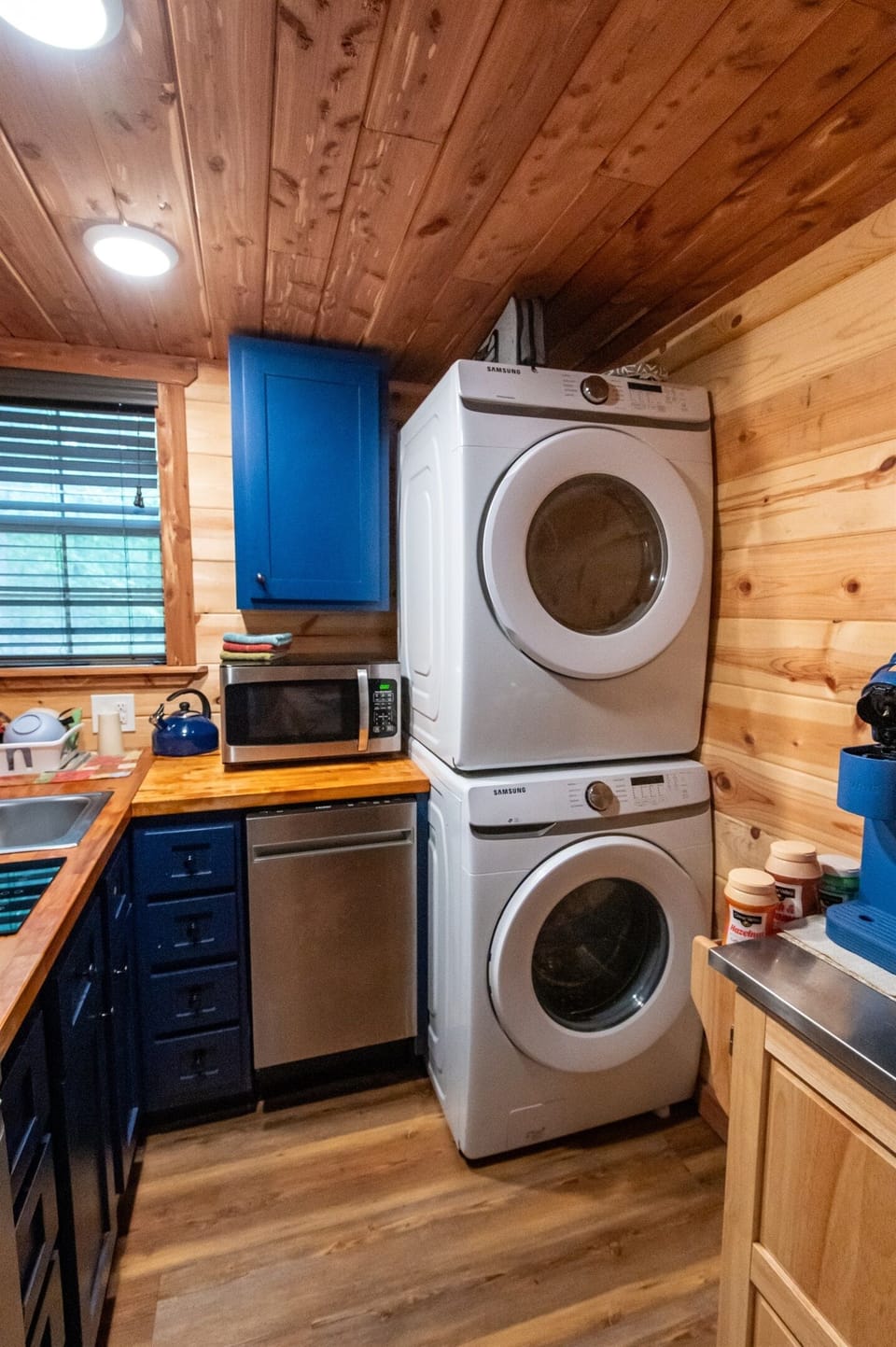 - Compact kitchen corner with washer dryer setup   - Blue cabinets and wood counters add cozy cabin charm   - Full convenience for extended forest stays forest cabin retreat