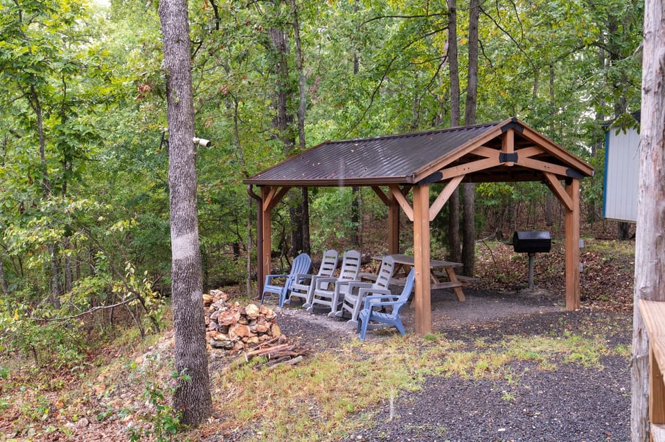 - Covered pavilion with firepit and forest seating   - Rocking chairs and picnic setup for gatherings   - Peaceful outdoor hub for evenings and meals