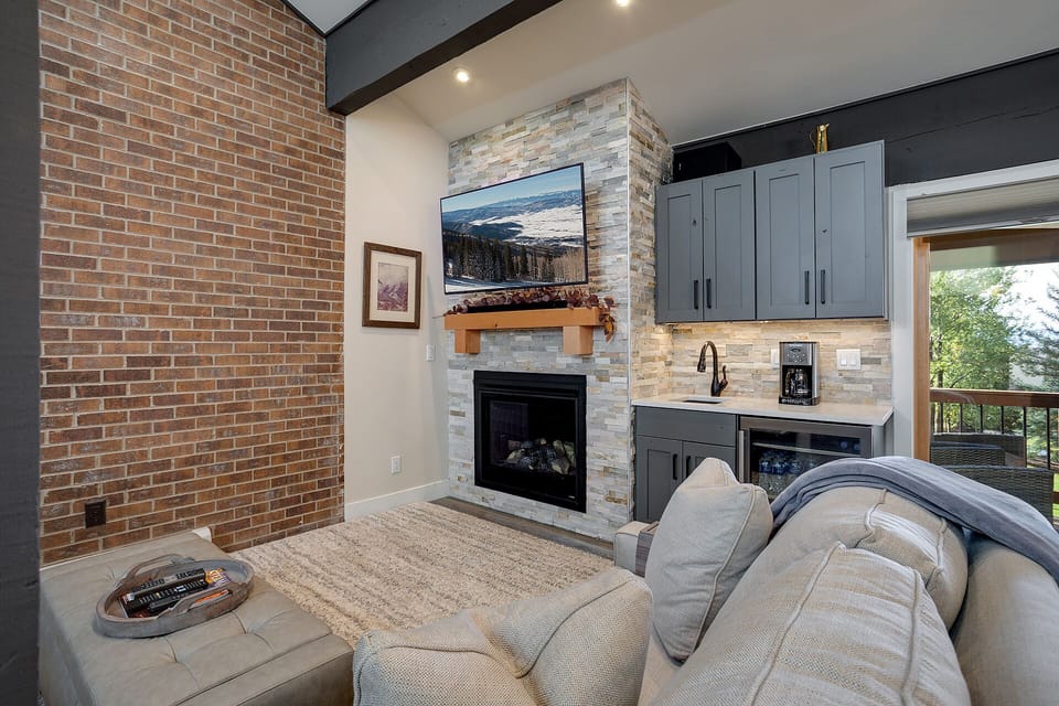 Sink into plush seating by your crackling fireplace, where rustic brick meets modern comfort in this stylish living space.