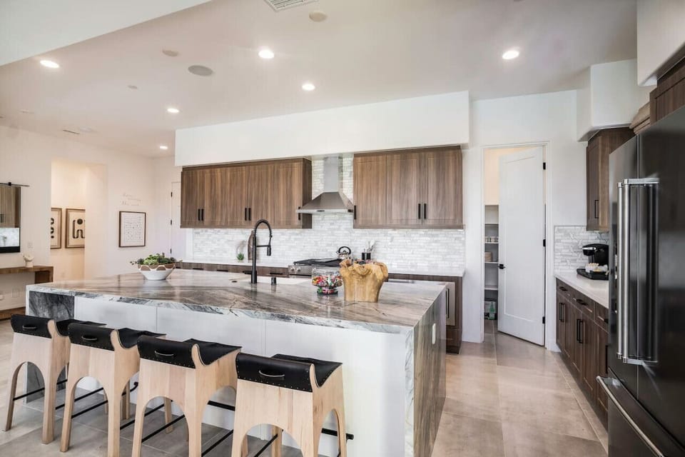Spacious chef’s kitchen w/ oversized island seating & stainless steel appliances