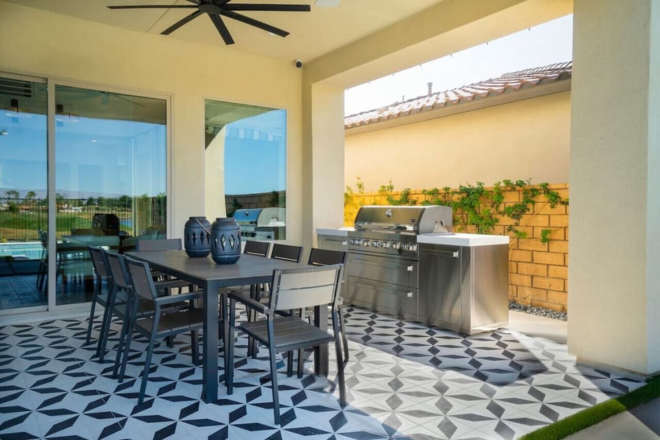 Covered patio dining space w/ grill & patterned tile floors for effortless outdoor meals