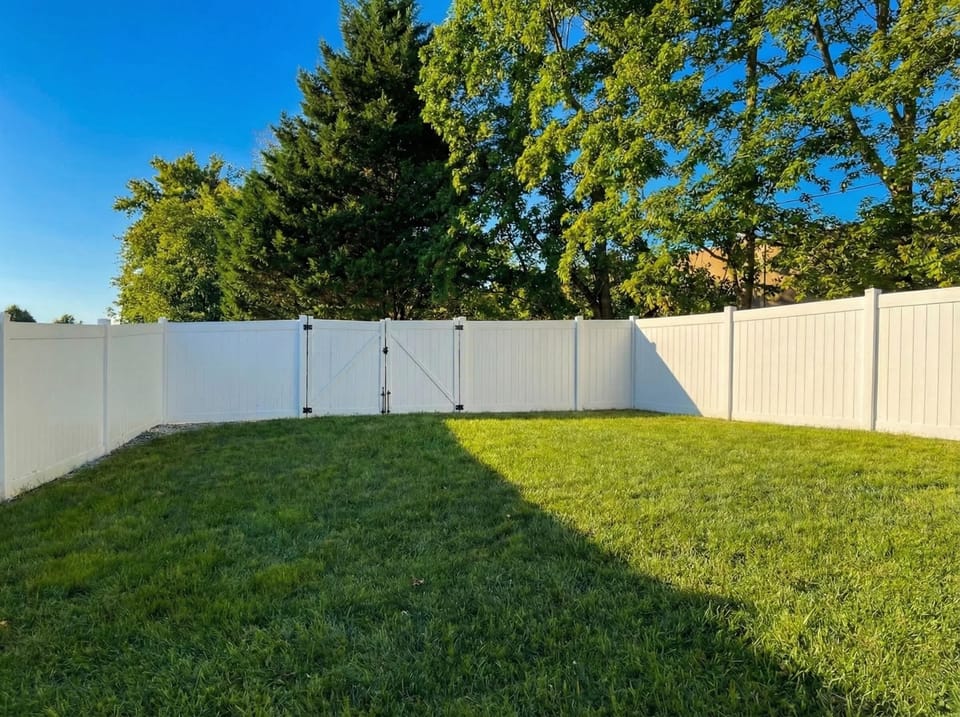 Fenced backyard with open lawn space.