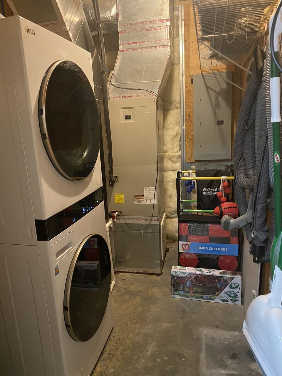 full laundry room with new stacked washer and dryer