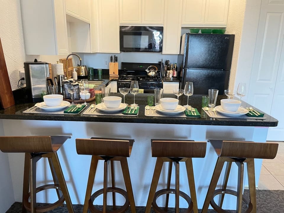 Full set of dinnerware and glassware, placemats, and cloth napkins for dining in.