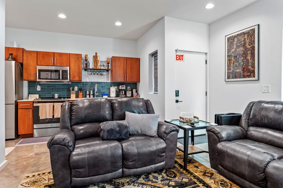 The living room/kitchen area has been updated with a new rug and a red couch.