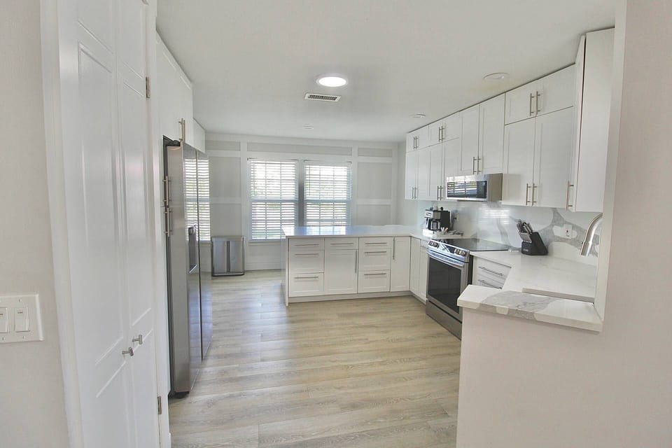 The fully remodeled kitchen boasts gorgeous cabinetry, white marbled quartz countertops and top of the line stainless steel appliances.