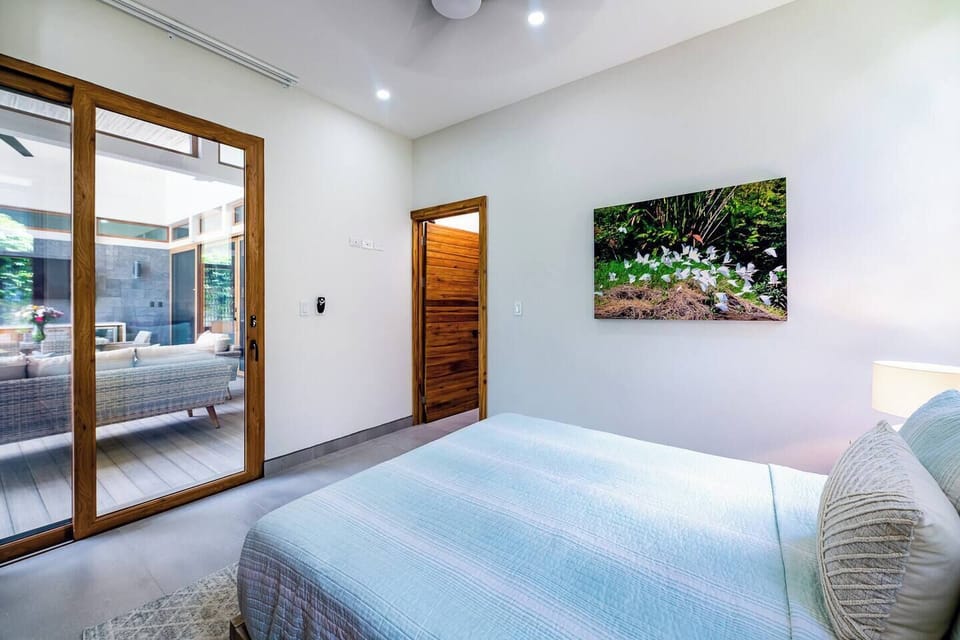 Elegant guest suite with a queen-size bed, air conditioning, and carefully designed furnishings, offering a serene retreat in this Costa Rica holiday villa.