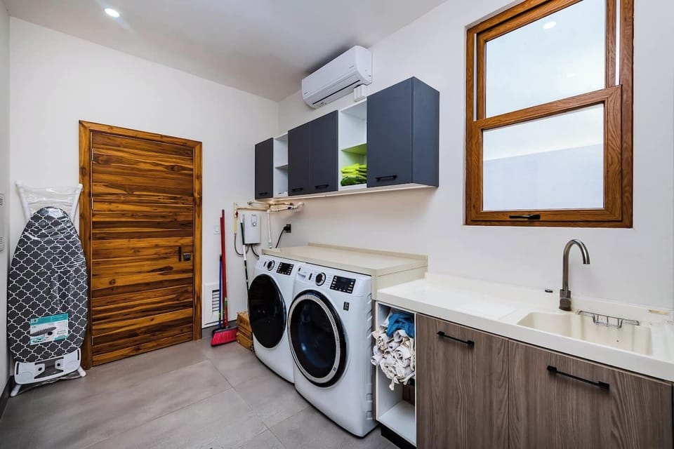 Convenient laundry area with modern washer and dryer, making long stays comfortable and hassle-free in your Playa Langosta vacation villa in Costa Rica.