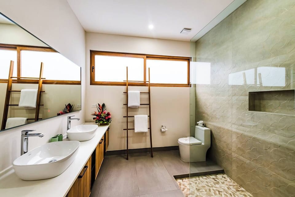 Modern guest bathroom featuring sleek, contemporary fixtures and a bright, sun-lit airy design. Experience ultimate style and convenience at this premier Playa Langosta vacation rental villa in Tamarindo Costa Rica.
