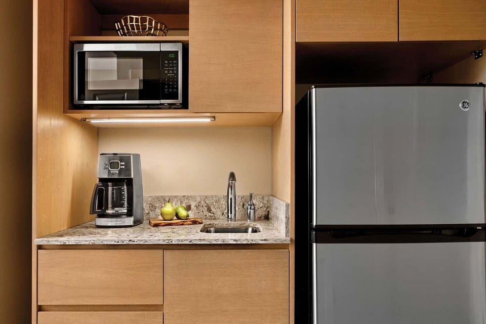Kitchenette includes a refrigerator, microwave, drip-style coffee maker, and sink.