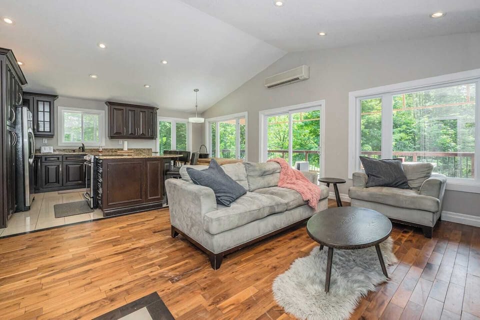 Warm and inviting living room with gorgeous fireplace, open concept kitchen that is fully equipped, massive dining table and access to the upper veranda. 