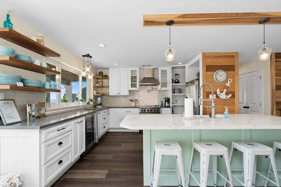 Stylish kitchen with custom shelving, modern appliances, and coastal accents