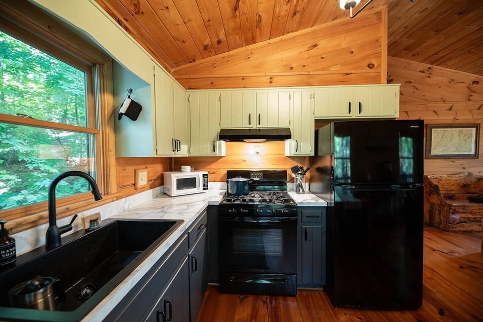 Kitchen with new appliances: gas stove, full-size fridge/freezer and dishwasher.