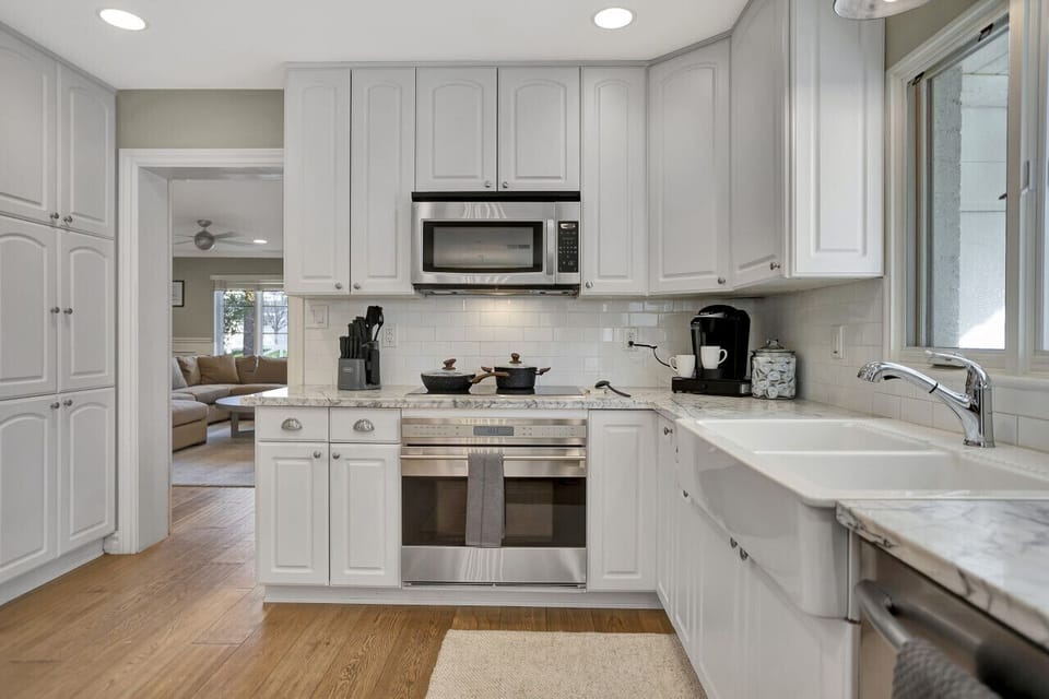 Pristine countertops, white double sink, and built-in appliances