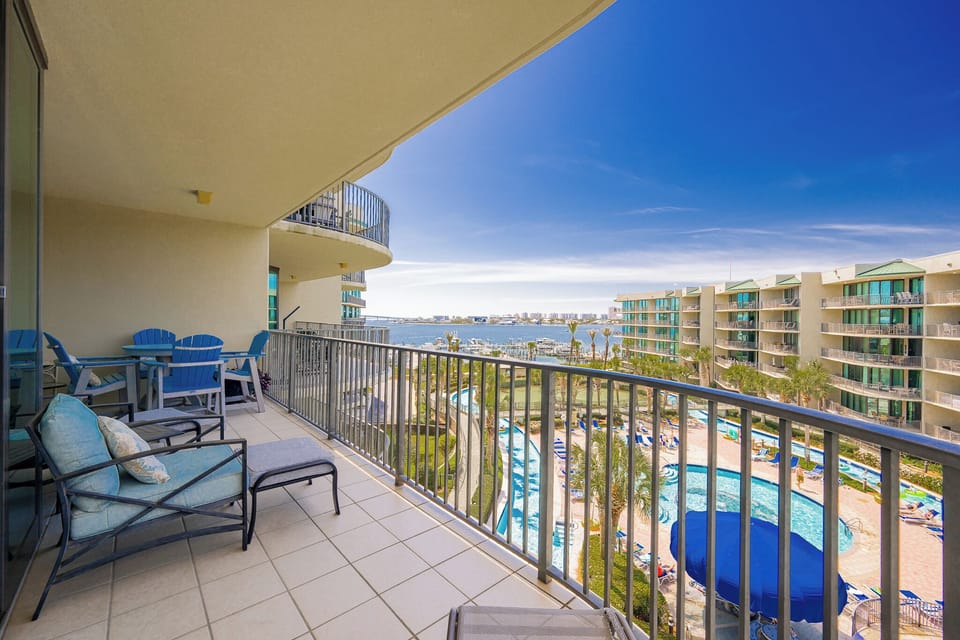 Lounge on the balcony overlooking the refreshing pool, lazy river, stunning bay water, and marina activity
