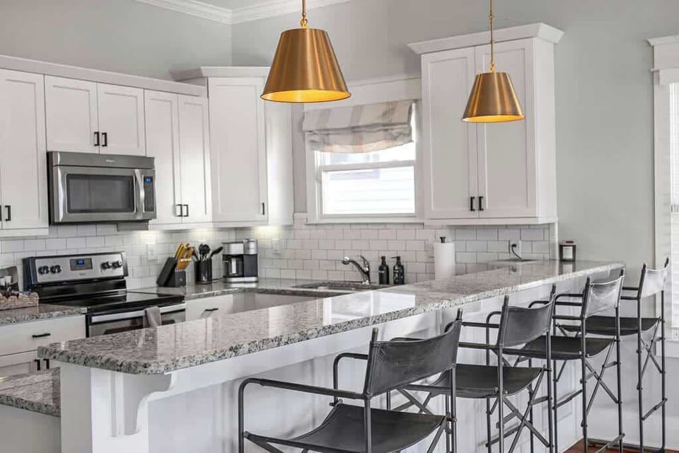 Sleek kitchen with granite bar, seating for 4 & stainless appliances