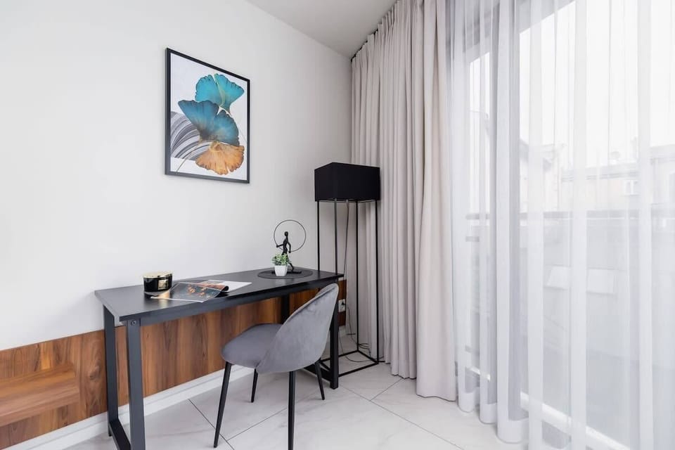 A bright corner with a large window and a desk setup, perfect for work or relaxation.
