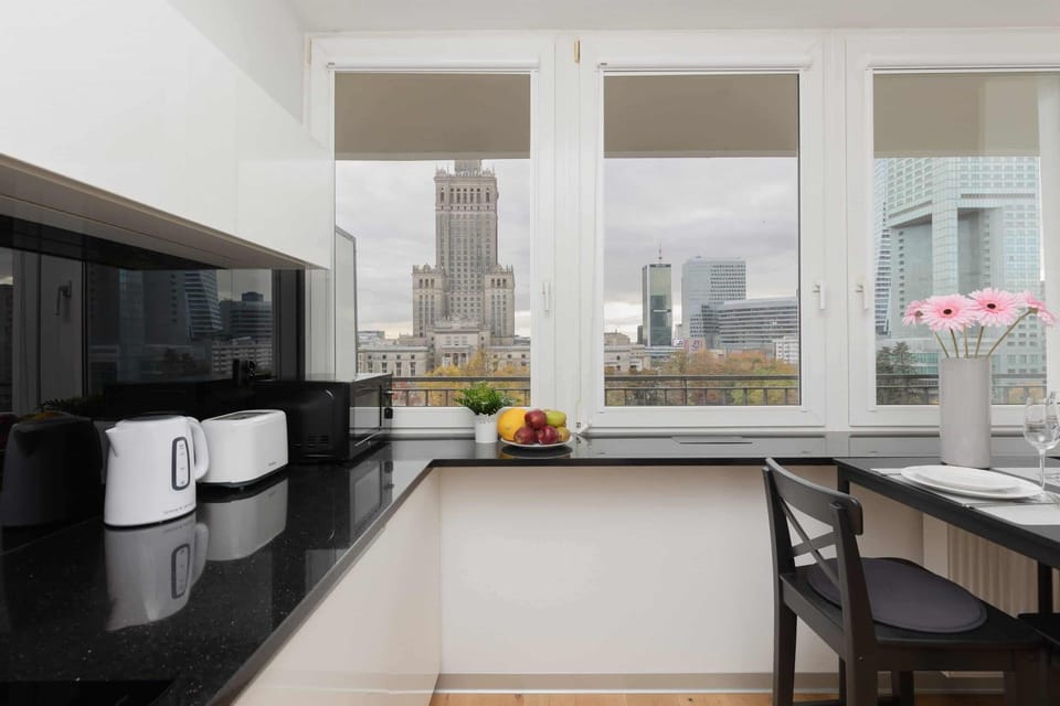 A close-up of the kitchen, featuring modern appliances and a window framing the urban landscape.
