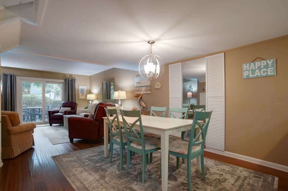 Gather around your charming dining table where warm lighting and coastal colors create perfect moments for shared meals and conversations.