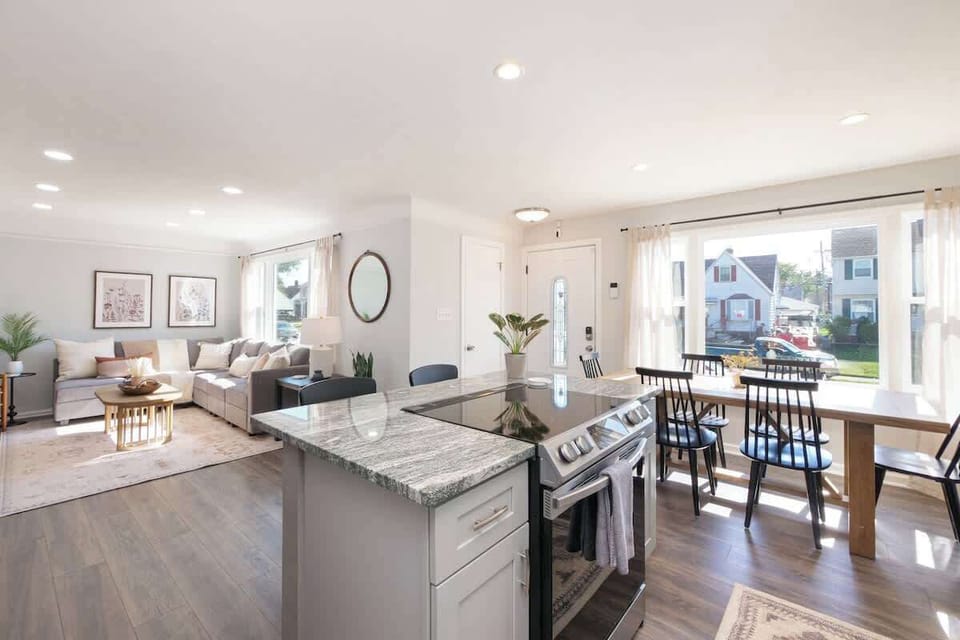 Sleek granite island with breakfast bar seating for three, perfect for casual meals or morning coffee, overlooking the dining table and living space. ️☕