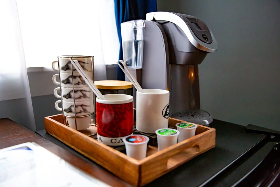 Coffee machine with K-cups and mugs are provided.