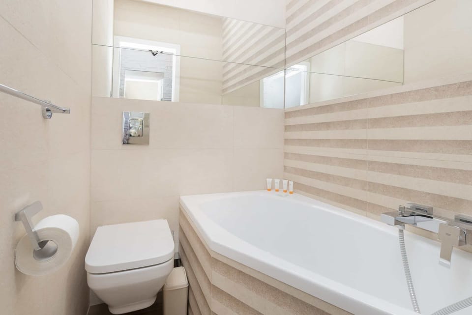 A clean and bright bathroom featuring a bathtub and minimalist decor.
