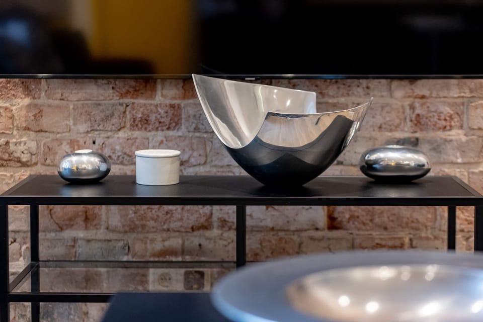 A close-up of table under the TV, featuring modern black and silver accents.
