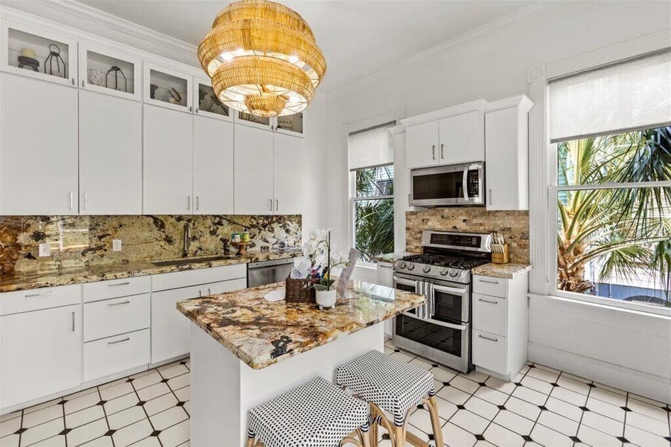 Bright and airy kitchen featuring sleek finishes and tropical views!