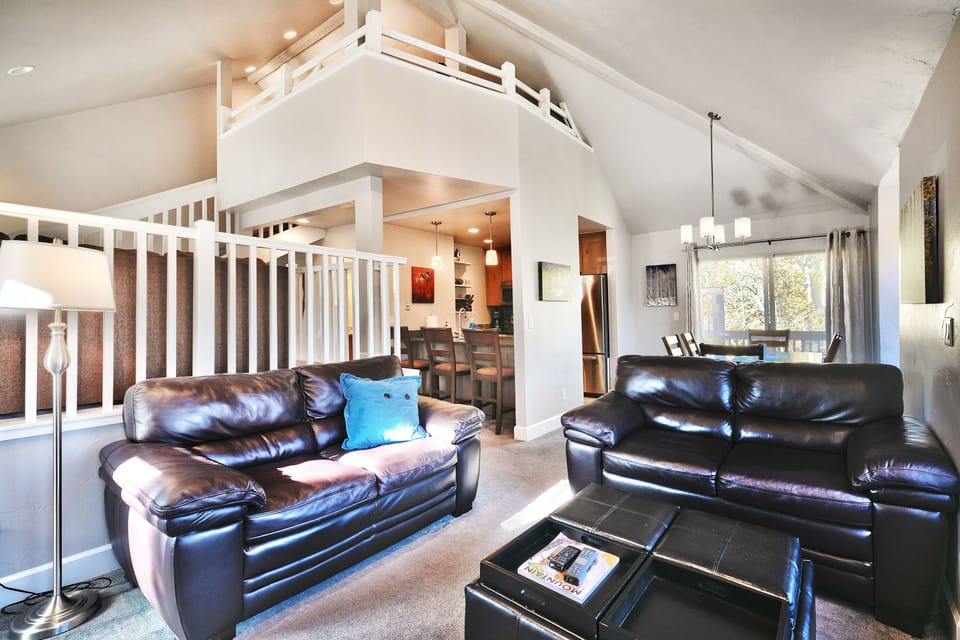 - Spacious living room with open loft design and cozy fireplace  
- Comfortable seating perfect for group gatherings or relaxation  
- Easy access to kitchen and dining for shared meals together