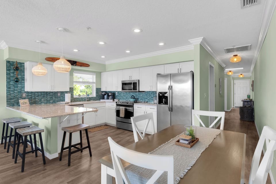 Large, well-equipped kitchen has a dining table/chairs as well as bar seating.