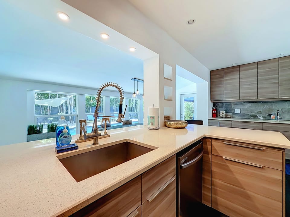 Deep undermount sink and brass faucet at the kitchen pass-through overlooking the pool.