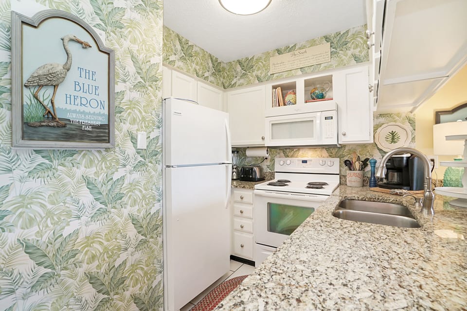 Your charming coastal kitchen invites culinary adventures with full appliances and tropical-themed décor that whisks you away to paradise.