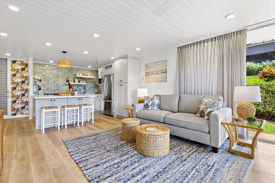 Modern Living Room & Open Kitchen - Bright, fully remodeled living area with stylish furnishings and an open kitchen featuring bar seating.