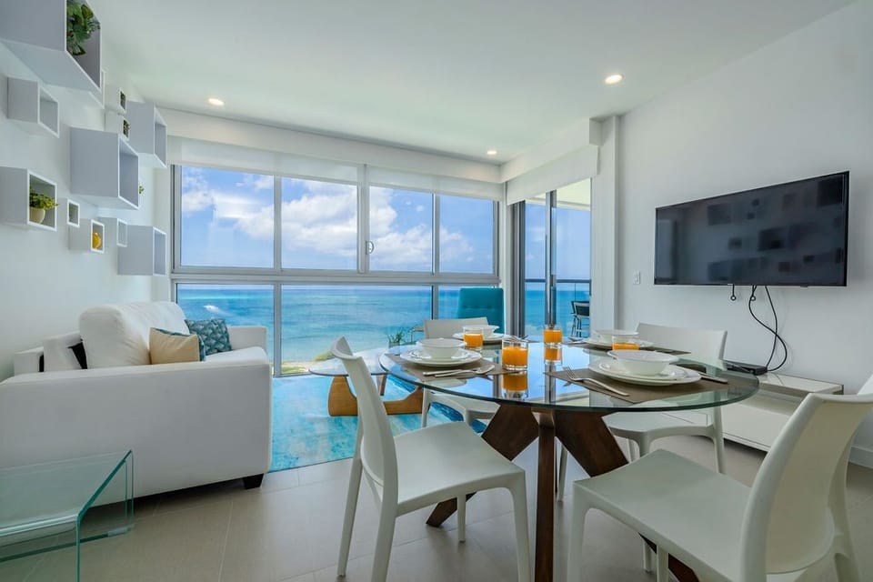 Wake up to breathtaking turquoise waters framed by floor-to-ceiling windows, where your open-plan living and dining space becomes a front-row seat to endless ocean views.