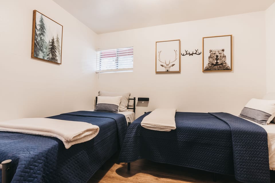 Small front bedroom (#2)  featuring two twin size beds and a large dresser.