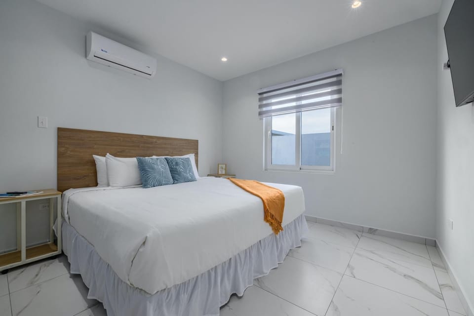 This bedroom has a king-sized bed, a TV and a window for natural lighting.