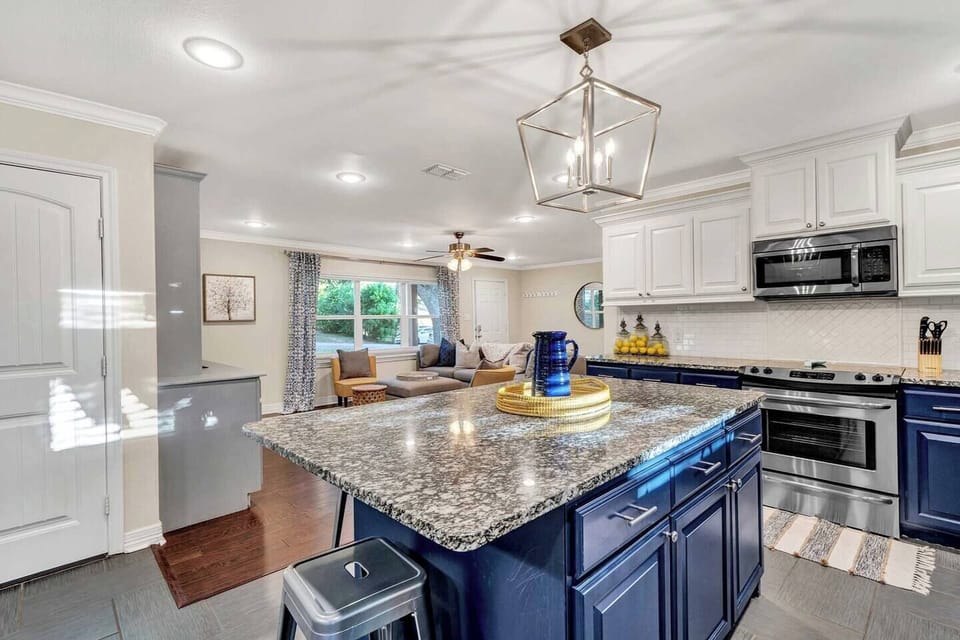 This stunning kitchen with bold blue cabinets and granite island flows seamlessly into the living area. Perfect for morning coffee, shared meals, or gathering around while conversations and laughter fill the space.