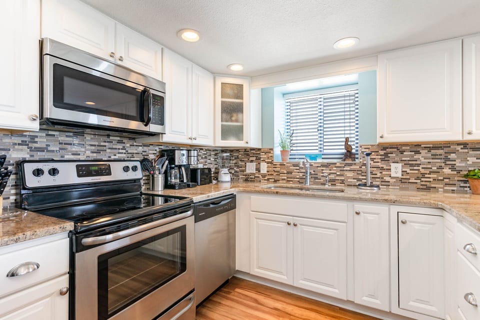 Your fully equipped kitchen awaits with granite counters, stainless appliances, and a stylish tile backsplash—perfect for preparing meals at home.