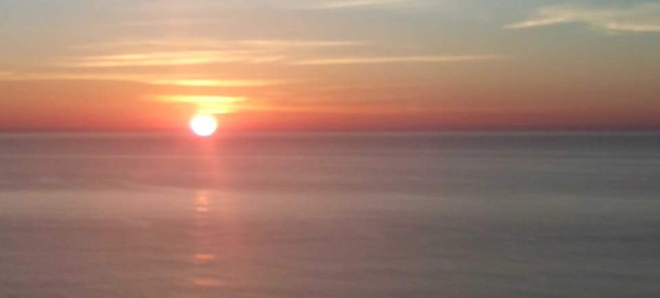 Beautiful sunset view over the water with golden hues painting the evening sky near the property.