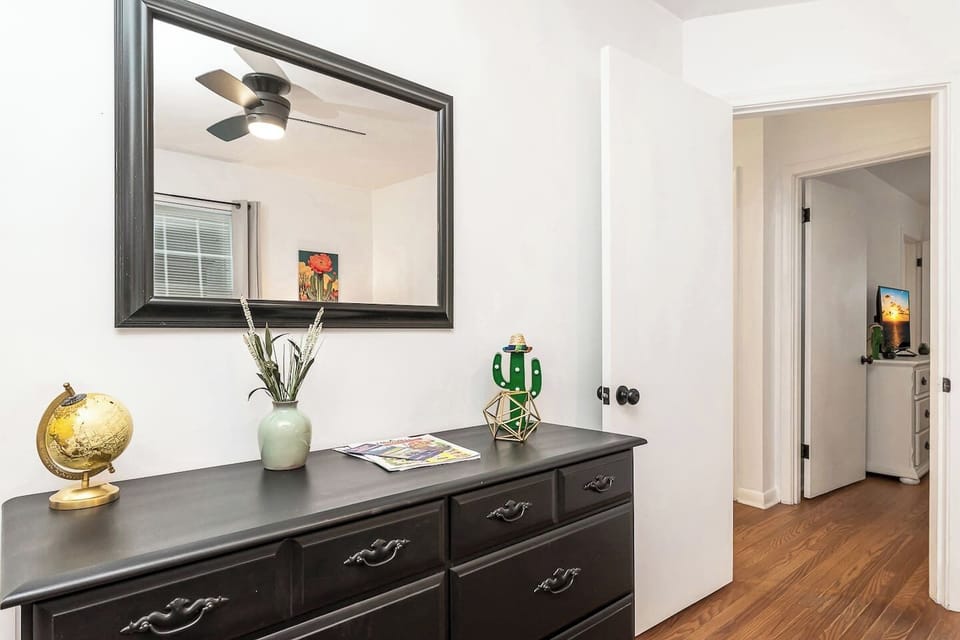 A thoughtfully designed bedroom entry featuring a spacious dresser and large mirror—perfect for unpacking and getting ready with ease. 