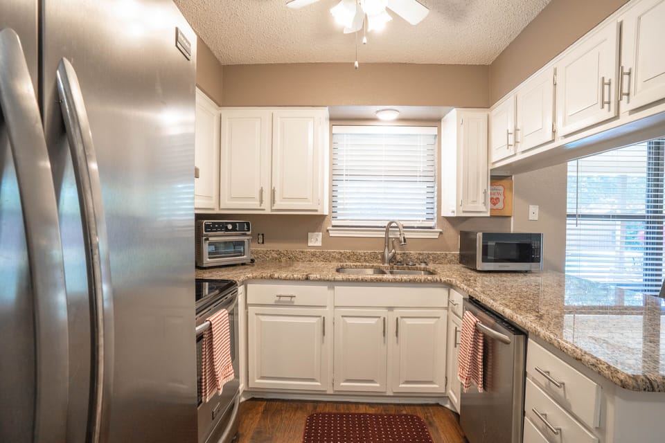 Stocked kitchen with stainless steel appliances, designed for long-term stays