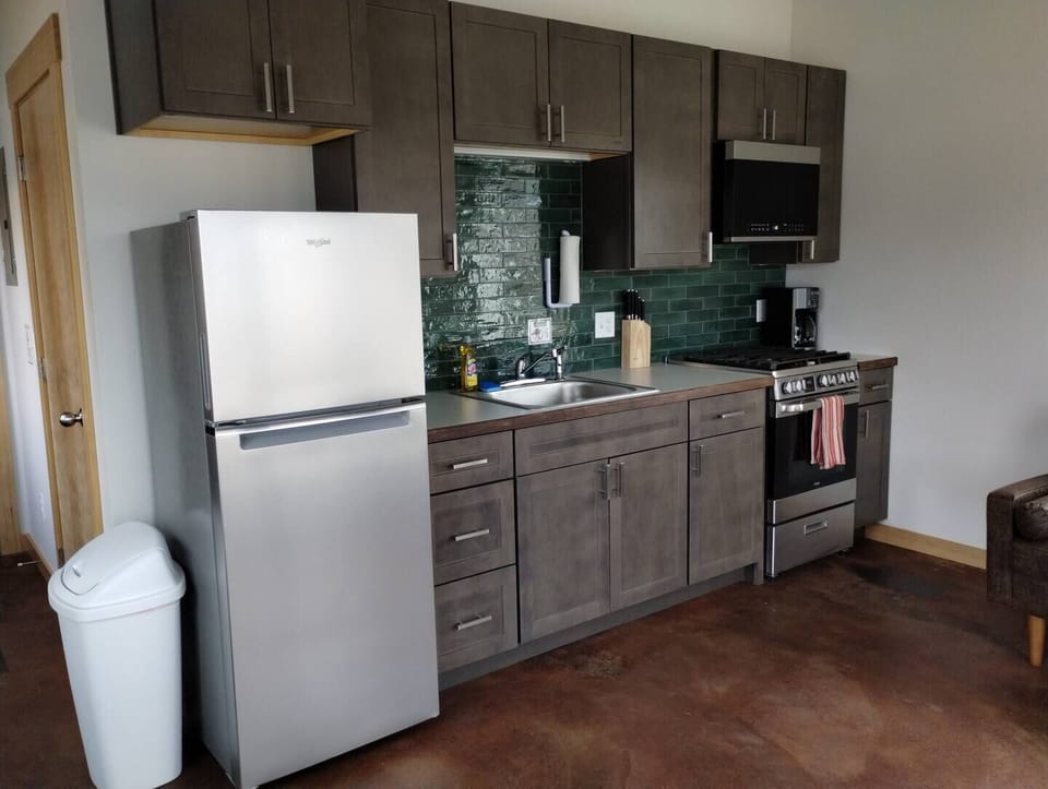 Fireweed Cabin – Kitchen Equipped with Fridge, 12-Cup Drip Coffee Maker, Toaster, Microwave, 4-burner stove with Oven, Tea Kettle, Coffee, Creamer, Sugar, Tea, Filters, and Basic Cooking Essentials.