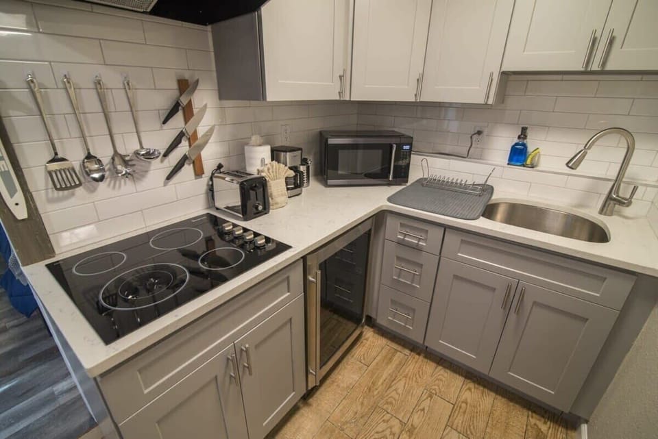 The kitchen is equipped as a kitchenette and features a wine/beverage -fridge, microwave, toaster, coffee machine, and stovetop.