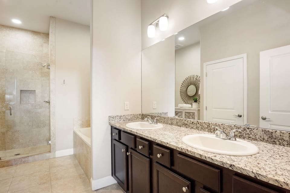 A master bath with large shower, dual sinks, and bath tub.