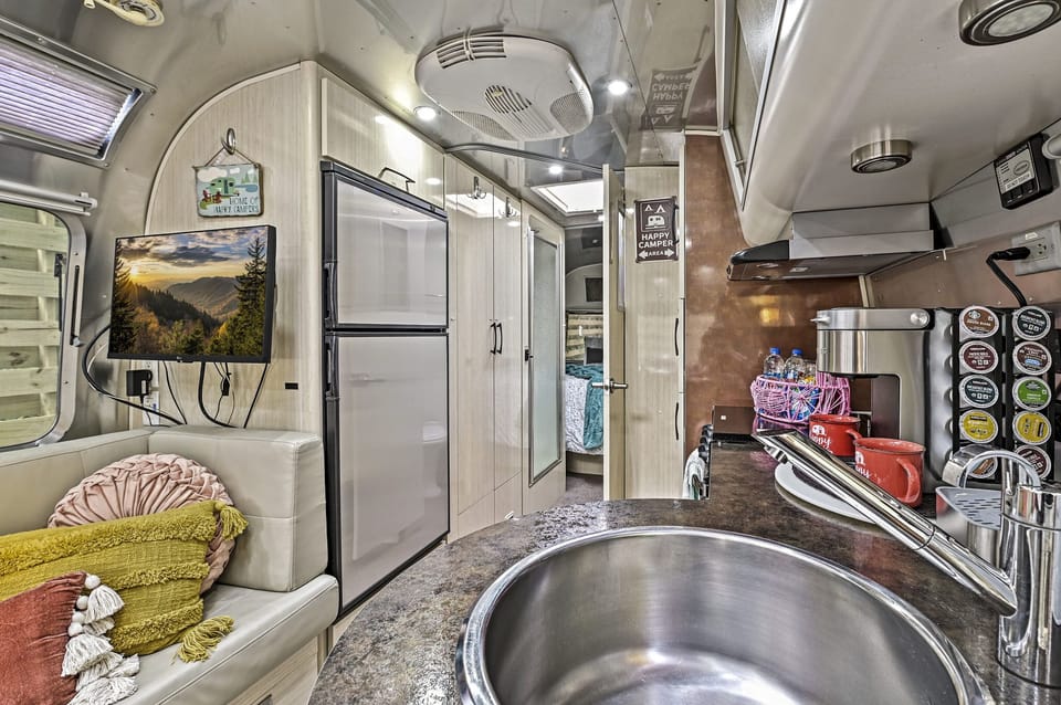 Living room and kitchen looking down towards the bathroom and queen sized bedroom.  All the comforts of home in an iconic Airstream trailer in the beautiful Smoky Mountains