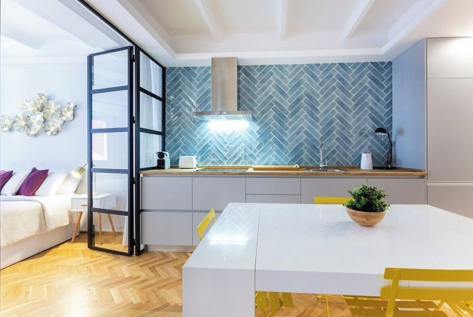 Detail of the dining table with the kitchen in the background and access to one of the bedrooms
